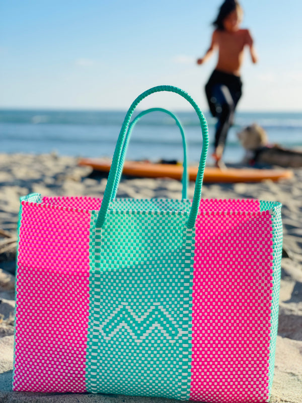 Woven beach tote bag in bright colors. 100% handwoven, made in small batches from recycled plastic. 